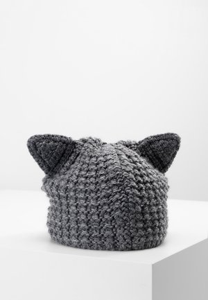 Bonnet gris en tricot avec deux oreilles de chat pointues, présenté sur une surface blanche avec un fond blanc uni.