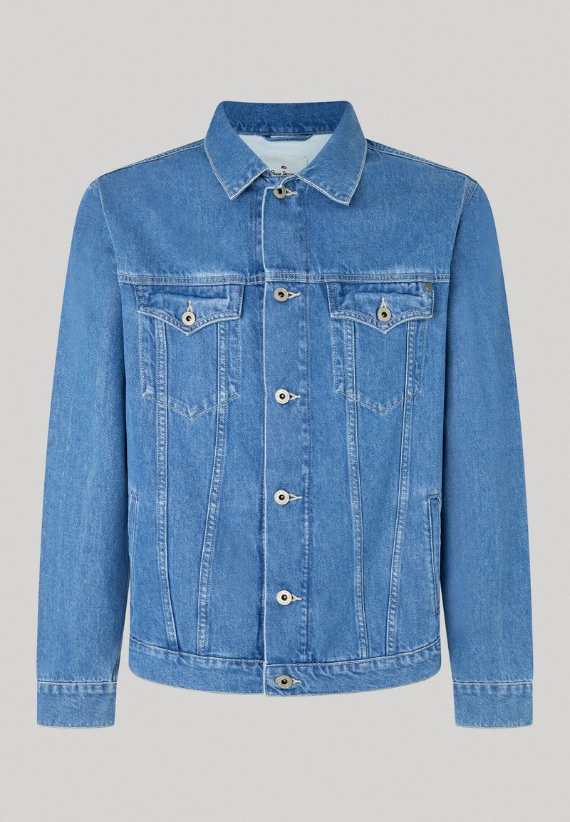 Chaqueta de mezclilla azul con cierre frontal de botones, dos bolsillos en el pecho y un cuello clásico. Presenta detalles de costura y una textura ligeramente desgastada.