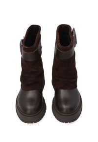 Brązowe skórzane i zamszowe botki za kostkę z grubą podeszwą, z elastyczną cholewką, regulowanym paskiem z klamrą oraz zaokrąglonymi palcami.