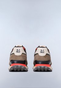Beżowe i brązowe zamszowe sneakersy z czarnymi akcentami, czerwonym detalem na pięcie oraz teksturowaną podeszwą zapewniającą przyczepność. Posiadają logo na pięcie.