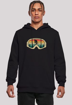 Black hoodie with a graphic of ski goggles featuring a sunset pattern, green trees, and a skier silhouette in the center. Cotton material.