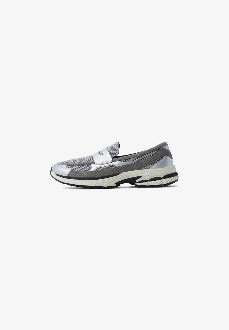 Sneaker im Slip-On-Stil mit grauem Netzobermaterial, silbernen Akzenten und einer dicken schwarz-weißen Sohle. Verfügt über einen gepolsterten Schaftrand und ein Detail mit Strap.