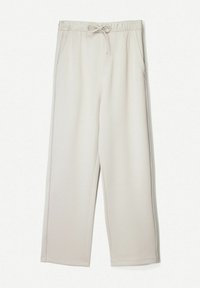 Beige, wijduitlopende broek gemaakt van zachte stof. Voorzien van een elastische tailleband met koordje en zijzakken voor opbergruimte. Soepele textuur.