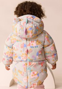 Padded coat with a hood, featuring a pastel pattern of animals and flowers. Soft, lightweight fabric, with elastic cuffs and multiple color accents.