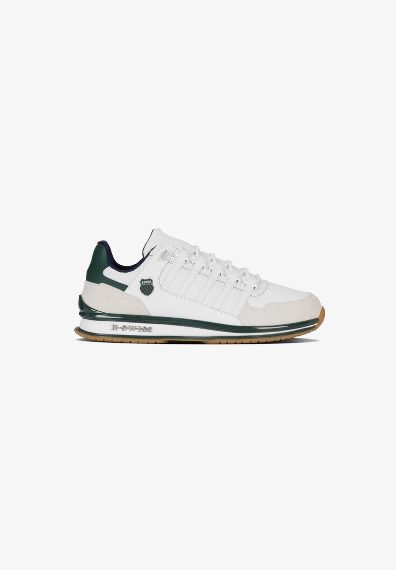 Baskets K-Swiss blanches et vertes avec design à lacets, bout en daim et logo de la marque sur le côté et la semelle, présentées de profil sur fond blanc.
