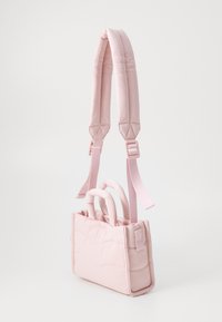 Sac à main rose matelassé avec un design rembourré, doté de poignées courtes et de bandoulières réglables. Texture lisse et coutures ondulées discrètes. Forme compacte.