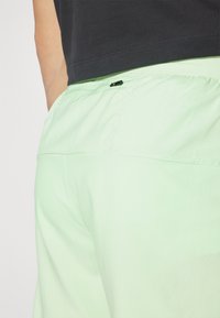 Nike Performance STRIDE - Sports shorts - vapor green/dark stucco/reflective silver
