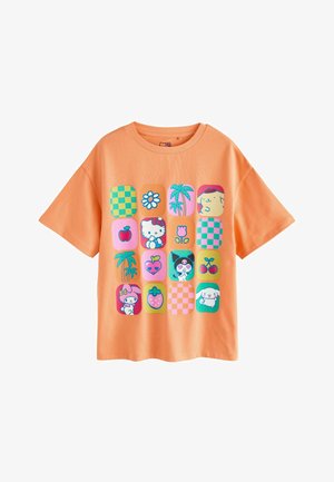 Brzoskwiniowy T-shirt z 16 kolorowymi kwadratowymi ikonami przedstawiającymi postacie z kreskówek, kwiaty, owoce i wzory w kratkę.