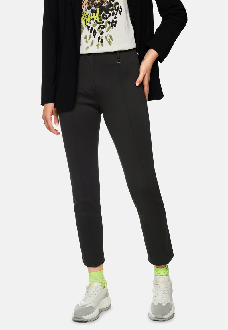 Black tailored pants with a slim fit, featuring front pockets, a smooth texture, and paired with white sneakers and neon green socks.
