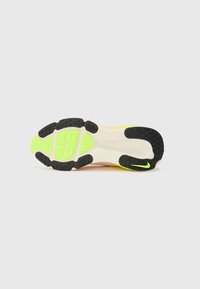 Nike shoe outsole featuring a black rubber tread with green and yellow accents. Smooth, textured surface with patterned grip areas.