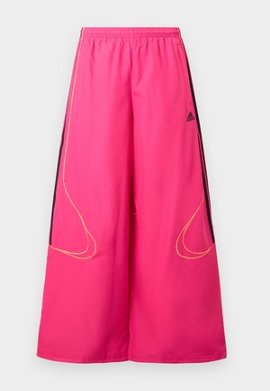 Roosad spordipüksid, millel on elastne vöökoht, laiad sääred, mustad küljetükid ja kollane õmbluse detail. Esiküljel on Adidas logo.