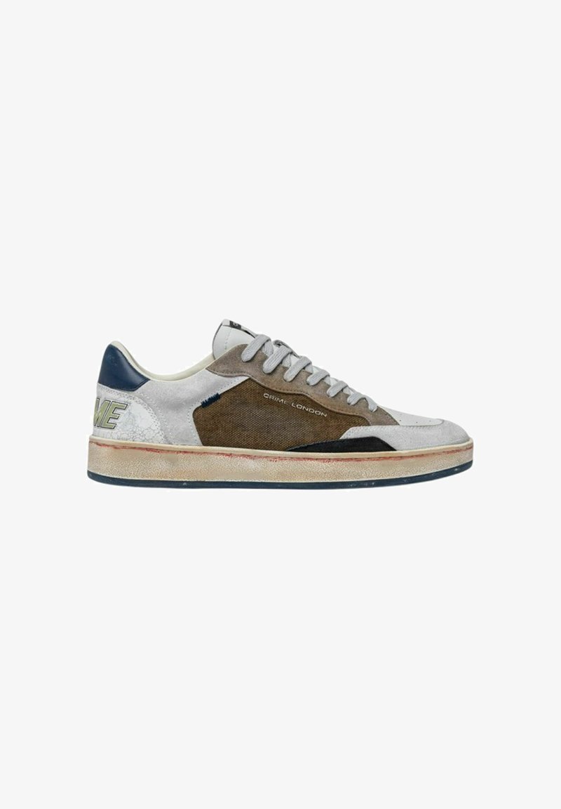 Sneaker basso con pannelli bianchi, marroni e blu navy, lacci grigio chiaro, suola beige consumata e marchio "Crime London" sul lato.