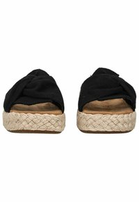 Zwarte stoffen instapsandalen met een gevlochten jute zool, voorzien van een gedraaide bovenkant en een platte voetbed voor casual gebruik.
