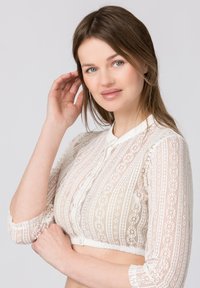 White lace crop top with a collar, featuring vertical stripes and floral patterns, long sleeves with button detail, sheer texture.