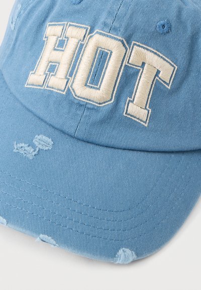 Zils kokvilnas beisbola cepure ar nolietotām detaļām, ar krēmkrāsas izšūtu tekstu "HOT" treknās burtu formās priekšpusē.