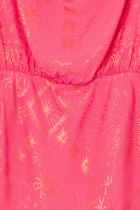 Tissu rose vif avec des motifs dorés complexes de soleils, d'étoiles et de formes organiques, avec une taille froncée pour un aspect texturé.