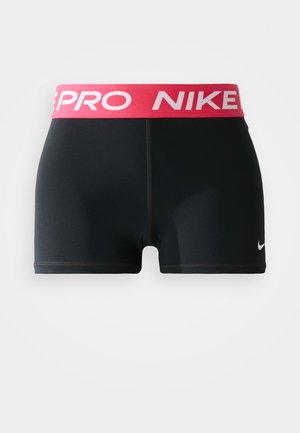 Črne atletske kratke hlače z rožnatim elastikom na pasu, ki nosijo napis "NIKE PRO", so izdelane iz raztegljivega materiala, imajo minimalne šive in majhen logotip.