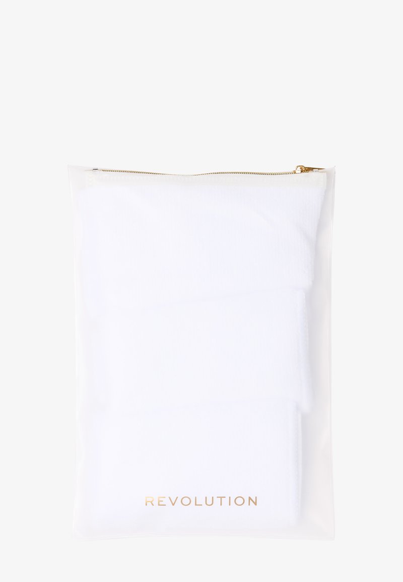 Białe bawełniane skarpetki w przezroczystej plastikowej torebce z złotym zamkiem błyskawicznym. Nazwa marki "REVOLUTION" nadrukowana złotem na dole.