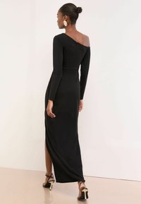 Melnā, pieguļošā maksi kleita ar garām piedurknēm un off-the-shoulder dizainu. Ar sānu šķēlumu un aizmugurējo rāvējslēdzēju. Gluda tekstūra.