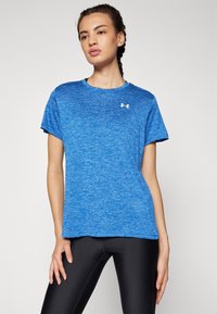 Camiseta atlética azul de manga corta, con un escote redondo y una sutil textura jaspeada. Presenta un pequeño logotipo blanco en el pecho.