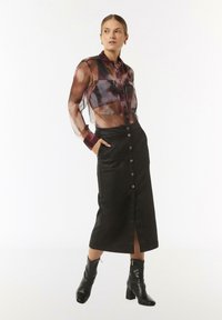 Transparent brown and purple sheer blouse with button front and collar, paired with a high-waisted black skirt featuring a front slit and buttons.