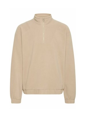 Beige fleece pullover with a high collar and quarter-zip closure. Features ribbed cuffs and bottom hem, featuring a subtle texture.