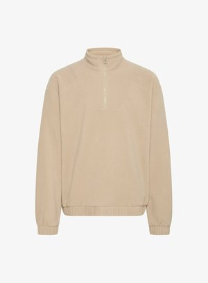 Sudadera de forro polar beige con cuello alto y cierre de media cremallera. Presenta puños acanalados y dobladillo inferior, con una textura sutil.