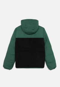 Padded jacket with a green, smooth fabric upper and a black, textured fleece lower section. Features a hood and elastic sleeves.