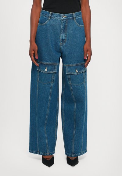 Bredde ben blå denimjeans med to forlommer, knaplukning og kontrasterende syninger. Glat tekstur med en afslappet pasform.