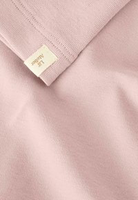 Svetloružová bavlnená tkanina s hladkou textúrou. Na okraji je viditeľná malá krémová etiketa s nápisom "LIT Acelater".