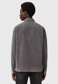 Grijze, corduroy, blouse met lange mouwen, een kraag, knoopmanchetten en een rechte zoom. Zachte textuur, minimale details.