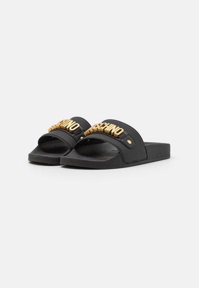 Schwarze Rutsch-Sandalen aus glattem Synthetikmaterial, mit einer strukturierten Fußbett und einem auffälligen goldenen Logo auf dem Riemen.