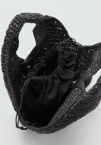 Sac fourre-tout tissé noir avec des poignées épaisses, comprenant une pochette en tissu noir à cordon à l'intérieur, offrant un contraste de textures.