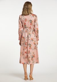 Rochie midi florală dintr-un material moale de culoare roz deschis, cu mâneci lungi, talie ajustată și diverse modele colorate de flori pe întreaga suprafață.
