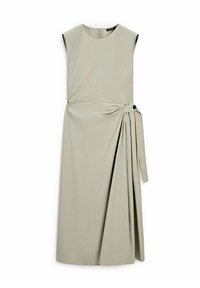Robe midi beige sans manches avec encolure ronde, jupe plissée asymétrique et ceinture en tissu avec un bouton noir sur le côté.