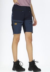 Pantaloni corti da outdoor blu navy con più tasche e accenti neri. Realizzati in materiale leggero, con zip e una patch con logo.