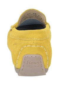 Gelbe Wildleder-Slipper mit weißer Steppnaht, gebrandeter Fersenanhänger mit der Aufschrift "Sioux Since 1954", zeigt das innen gestreifte Futter und die Größenangaben.