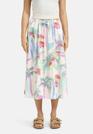 White midi skirt with colorful palm tree and beach cart print, worn with beige sandals and a white sleeveless top.