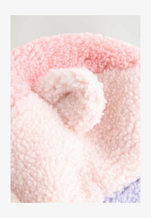 Perna rotundă din material textil în nuanțe de roz și roz deschis, având o textură moale și pufoasă, cu un accent de buclă vizibil pe suprafață.