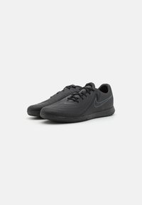 Zwarte sportschoenen met een gestructureerde oppervlakte, voorzien van een slank ontwerp, veters en een subtiele logo-accent aan de zijkant. Rubberen zool.