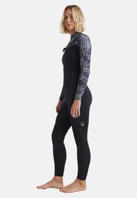 Black wetsuit with long sleeves, floral pattern on shoulders. Features textured material and fitted silhouette, with knee padding details.