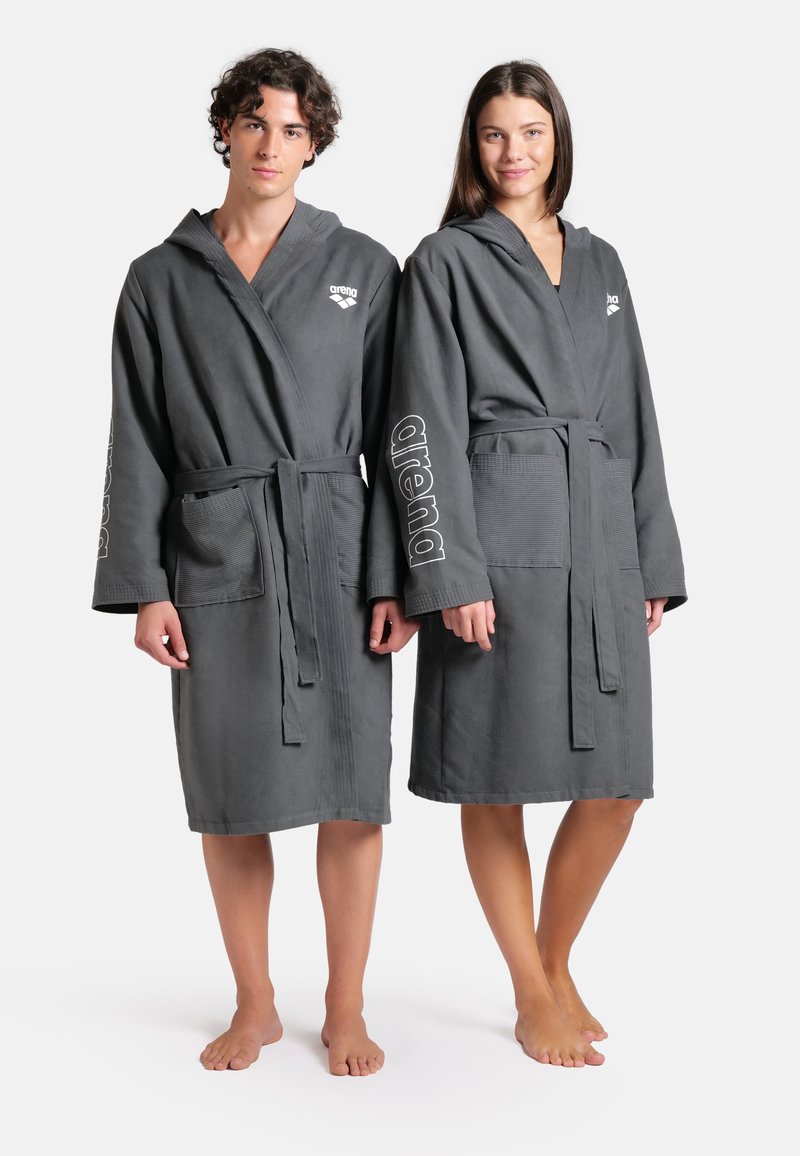 Šedé froté župany s kapucí, dlouhými rukávy, Opasky, dvěma předními kapsami a bílými akcenty loga 'arena' na rukávech.