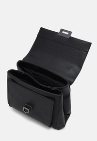 Svart syntetisk handväska med en strukturerad form, texturerad yta, magnetisk klaffstängning och en silverfärgad detaljer på det främre facket.