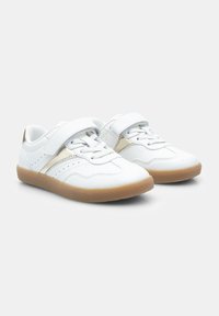Weiße Sportschuhe mit einer glatten Lederoberfläche, ausgestattet mit einem Klettverschluss, schnürbarem Vorderteil, hellgoldenen Akzenten und einer strukturierten Gummi-Sohle.