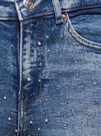 Zilas džinsa bikses ar izbalējušu tekstūru, priekšpusē izkaisīti sudraba nagliņas kā rotājums. Klasisks pogas aizdare un redzamas kabatas.