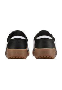 Zapatillas deportivas en blanco y negro con un empeine negro liso, acentos blancos y suelas de goma de color natural que presentan un patrón de agarre texturizado.