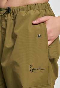 Olivengrønne cargo-shorts lavet af letvægtsstof, med elastisk talje, trykknap, sidelomme og broderet logodetalje.