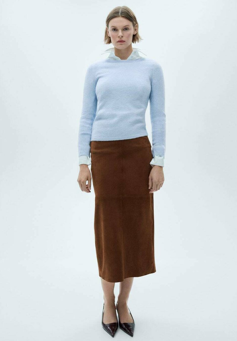 Light blue knit sweater, collared white shirt underneath, brown suede midi skirt, and black pointed-toe heels. Simple, fitted silhouette.