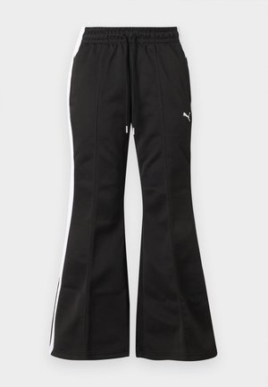 Schwarze ausgestellte Jogginghosen mit weißen Seitenstreifen, Kordelzugbund und Puma-Logo am linken Oberschenkel vor hellem Hintergrund.