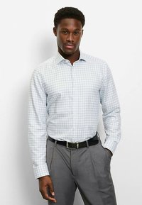 Light blue checkered button-up shirt made of fabric with a smooth texture, paired with gray trousers and a black belt.
